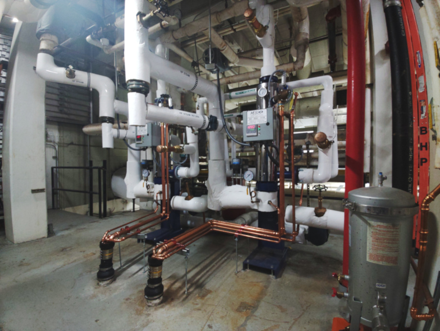 two new steam powered semi instantaneous water heaters side by side field connected insulated steam lines with copper drain/pressure temperature safety relief/high temperature safety solenoid/steam vacuum breaker piping to discharge drain